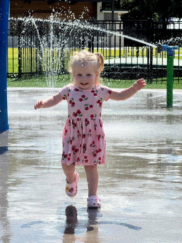 Scarlett enjoying the splash pad in Leland, North Carolina, as part of the story behind Scarlett's Little Gift.